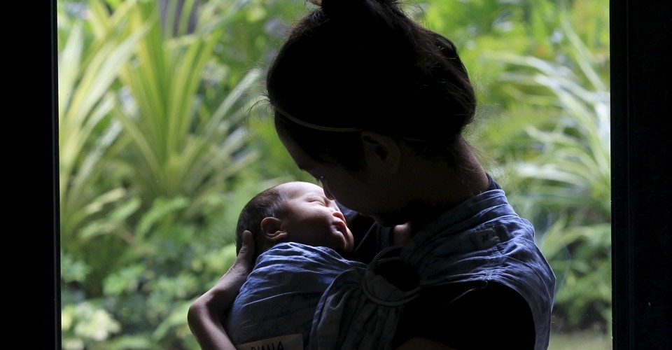 mother holding new born baby with nature background