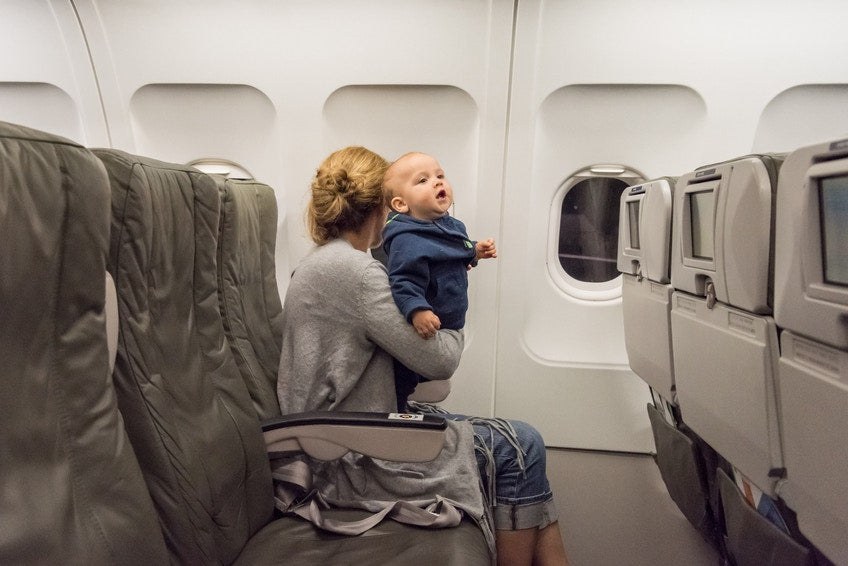 mother holding her baby in airplane