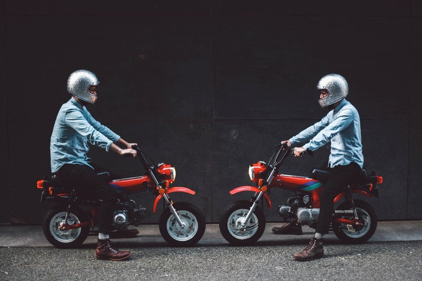 two men sitting in bikes facing opposite to each other