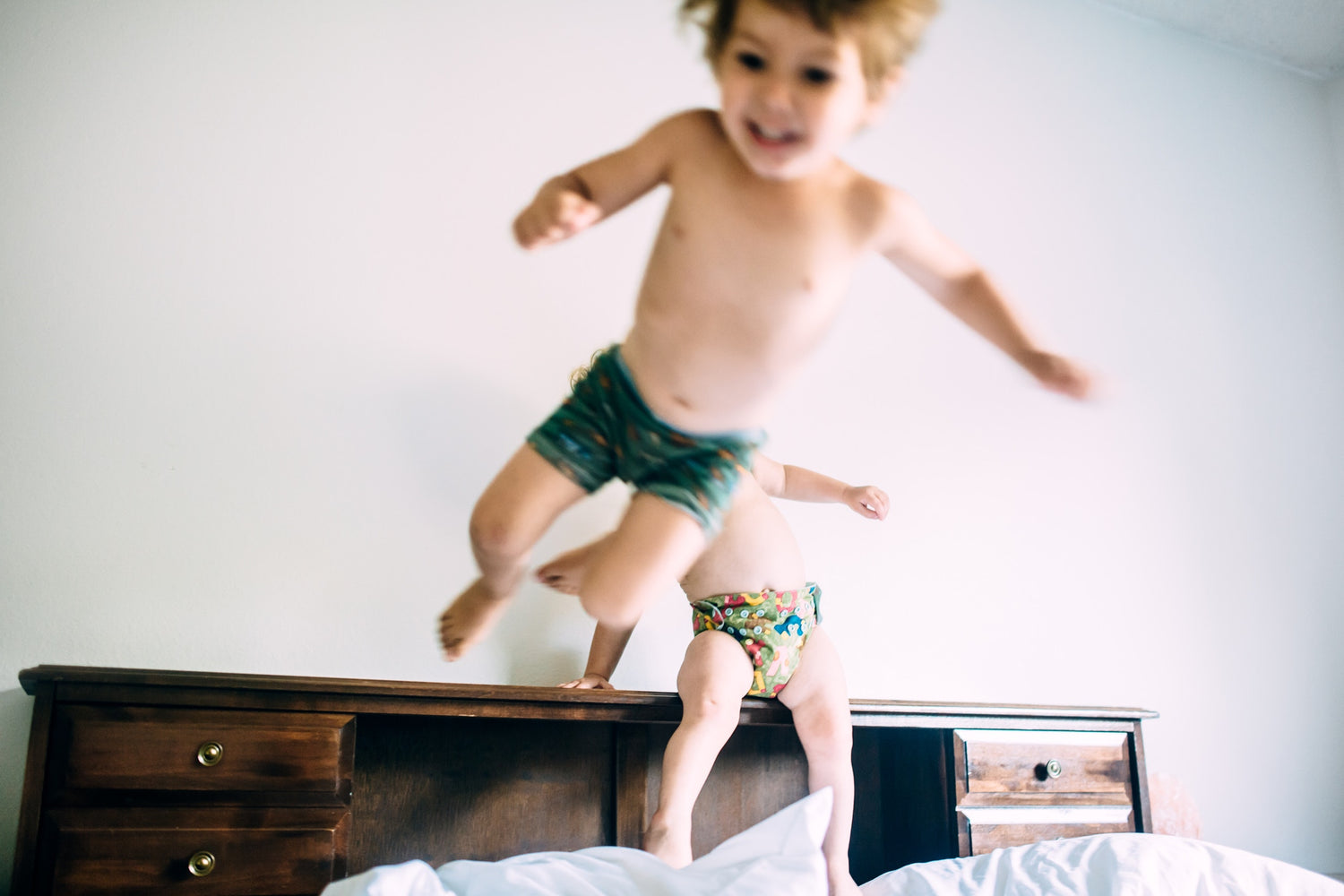 Two children playing in bed