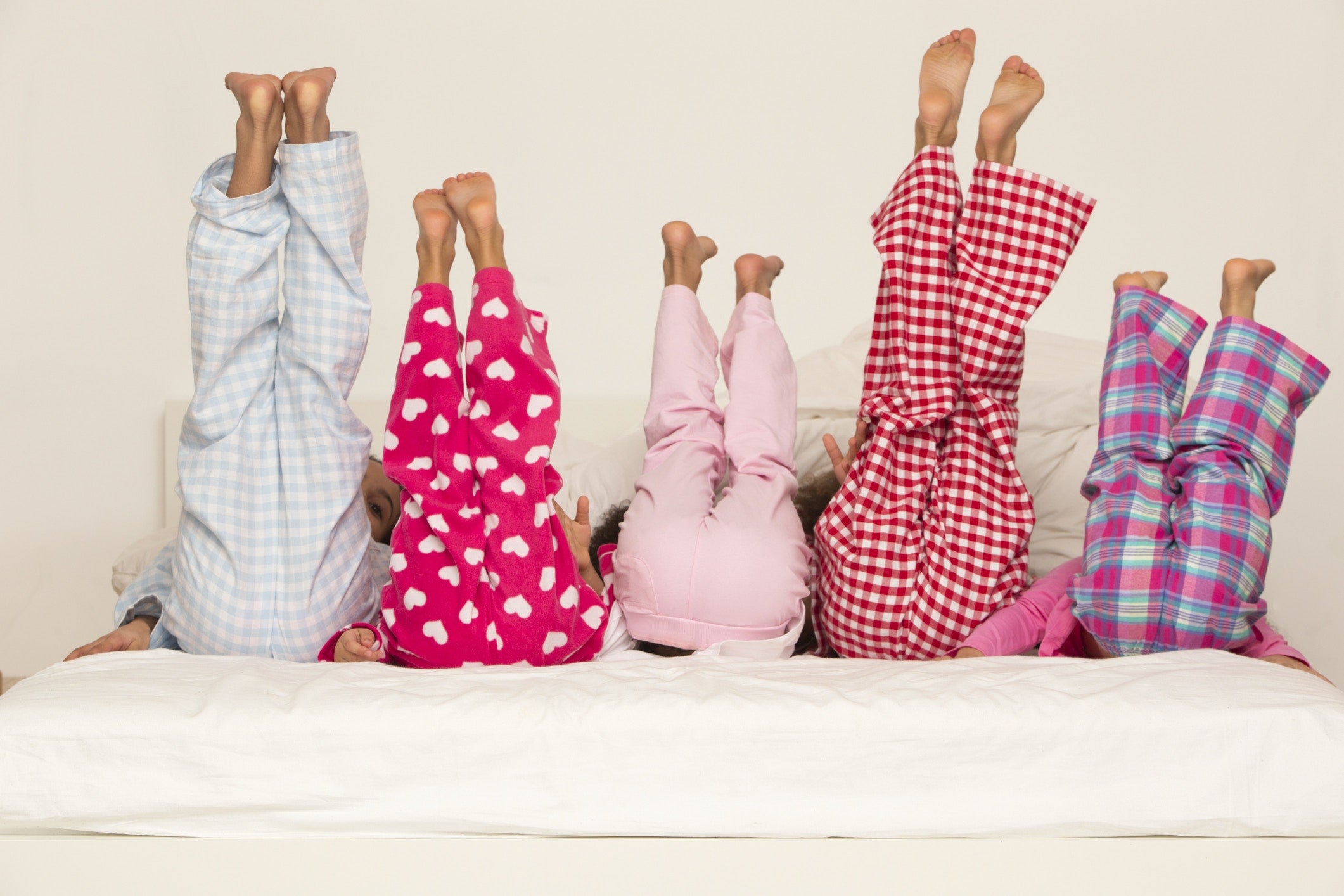 child lying on bed with her legs straight in the air