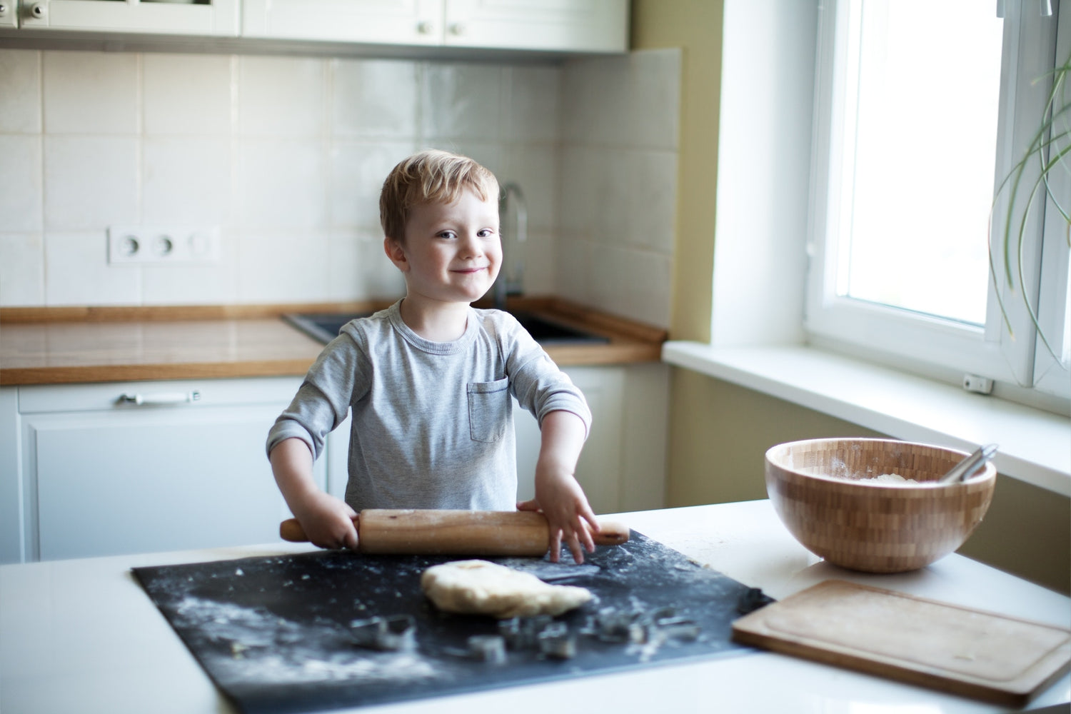 A child is making wheat chappati in the kitchen