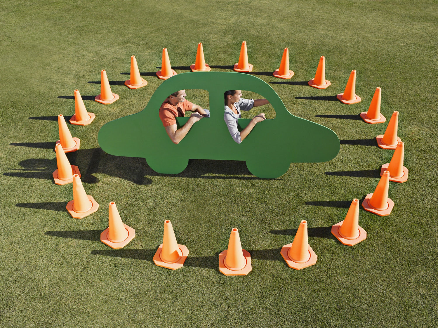 couple sitting in a car image surrounded by traffic cones