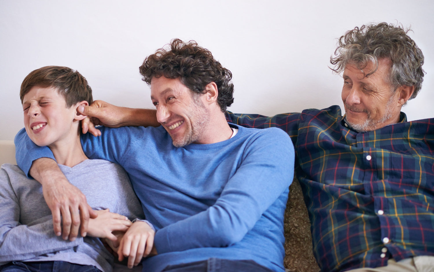 son, father and grandfather pulling grandson's ear