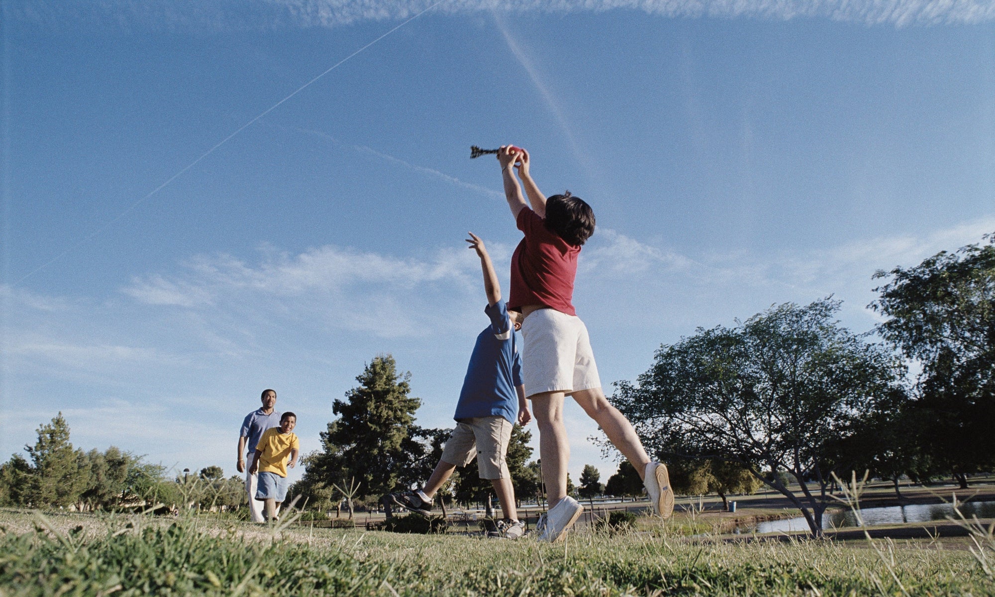 father playing with three sons at the field