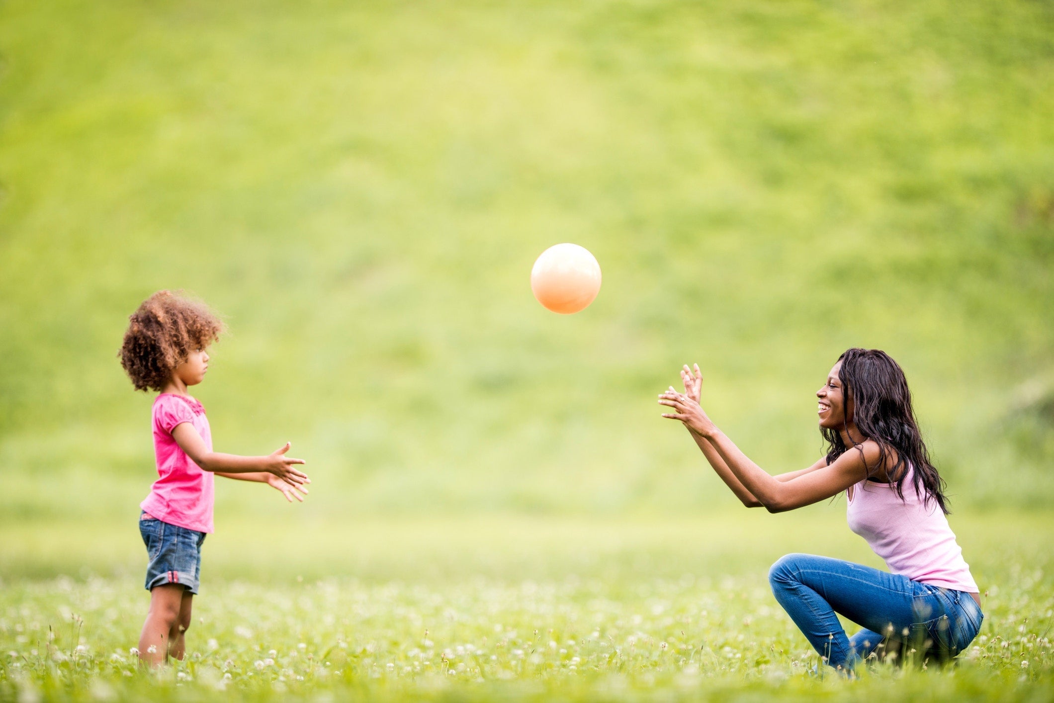 Mother And Daughter Playing In The Meadow