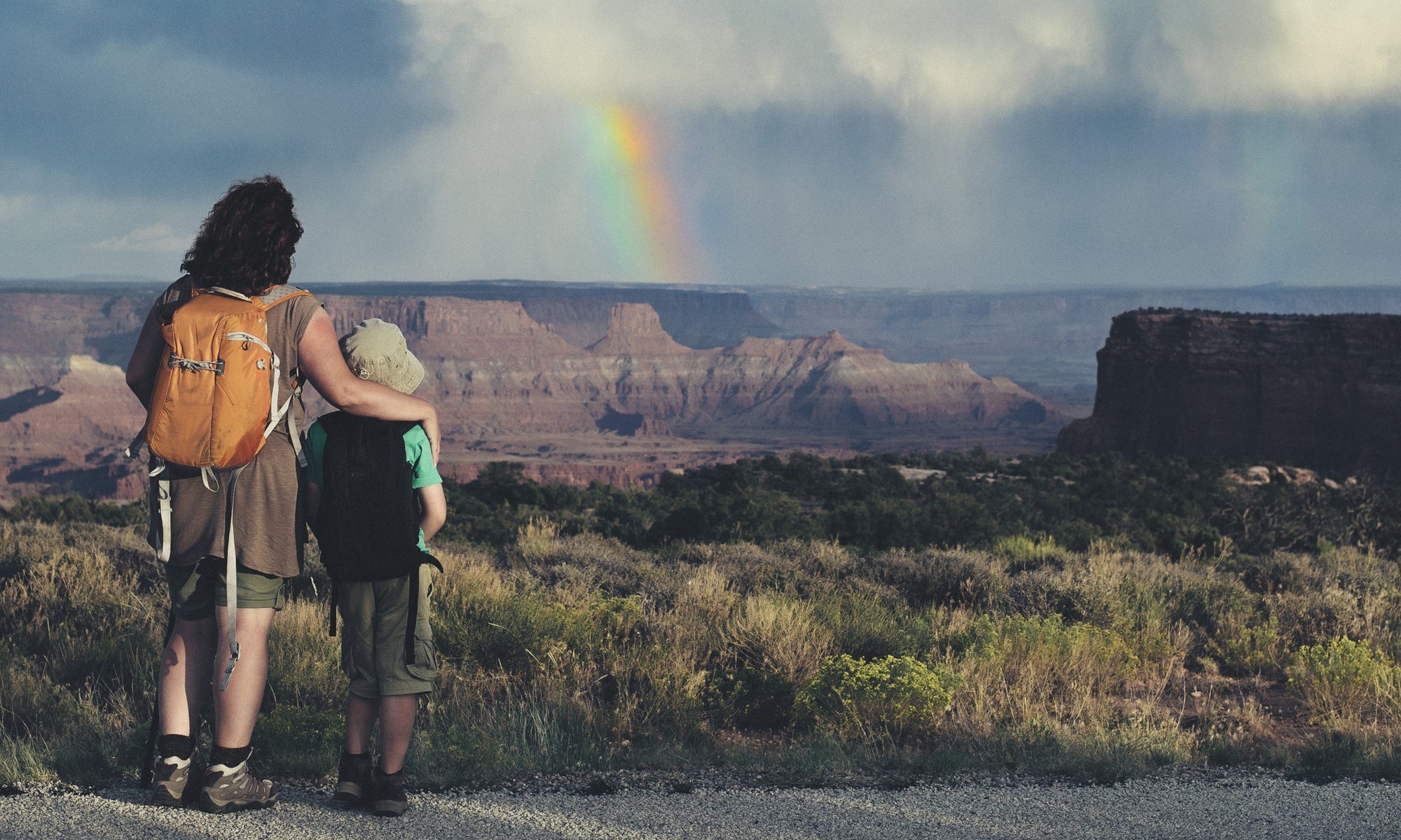 woman travelling with a child. Mother and son watching rainbow