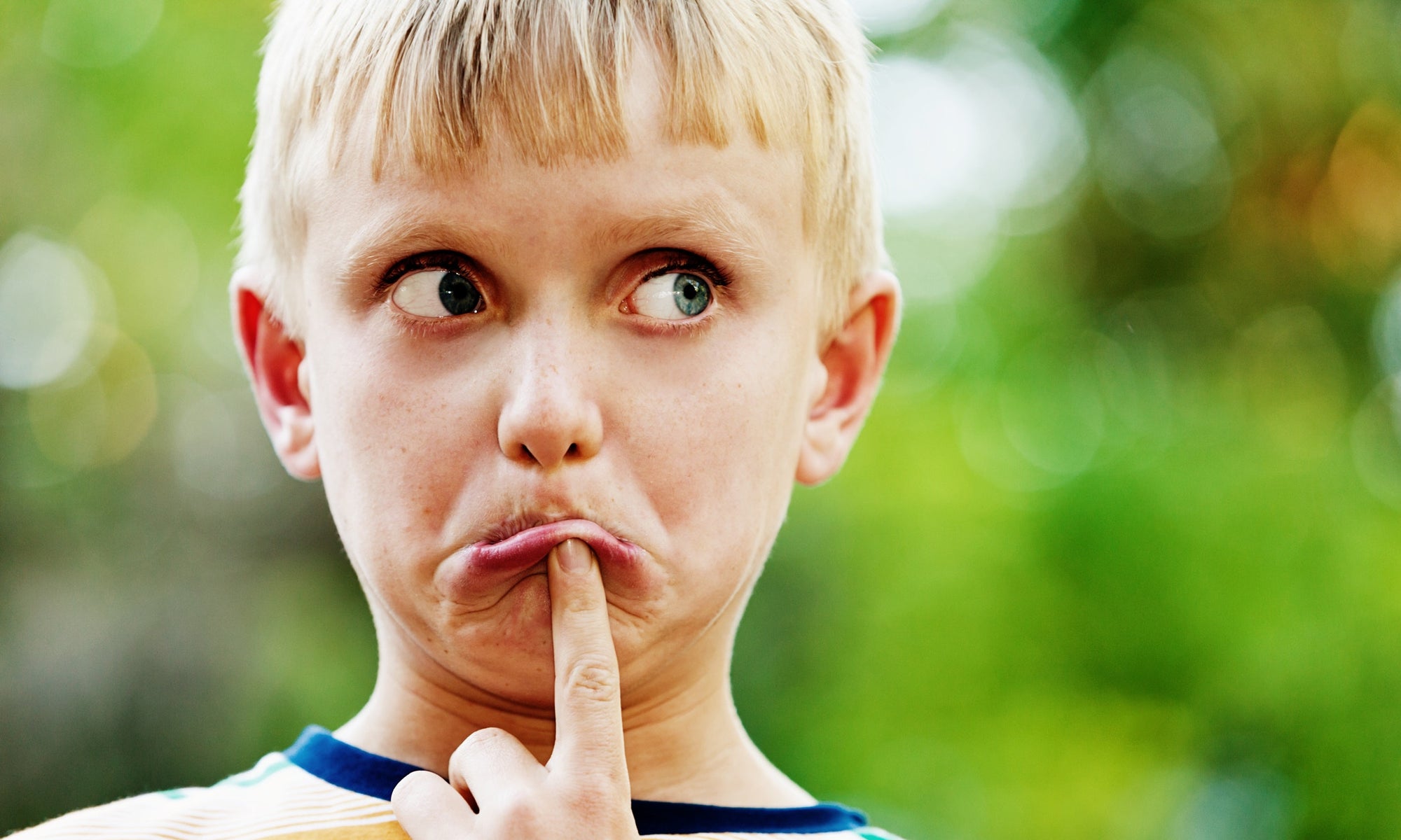 tensed little boy pushing his lower lip with finger