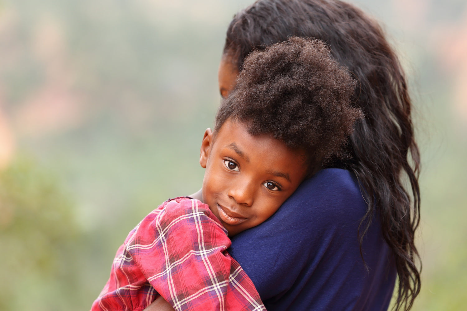 mother holding young kid resting on shoulder