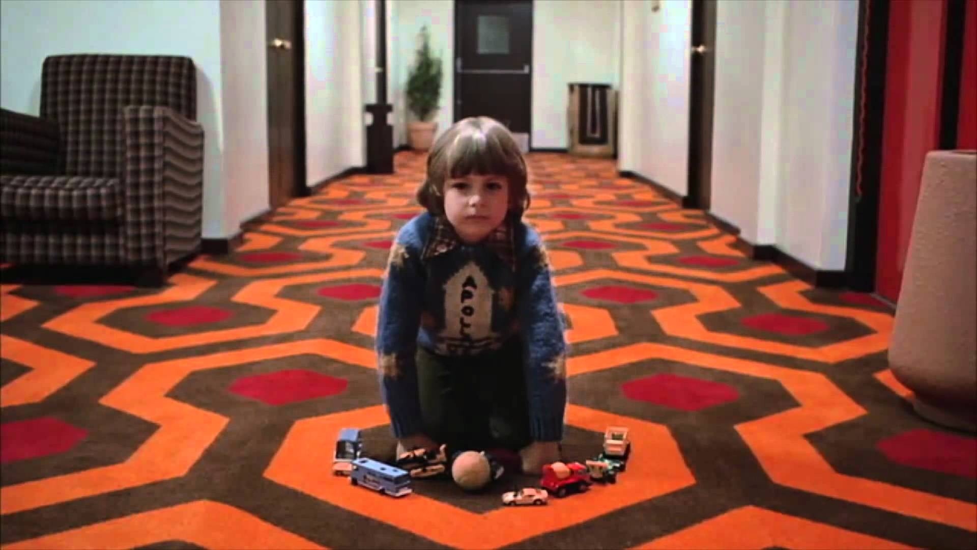 young boy on floor with various toys