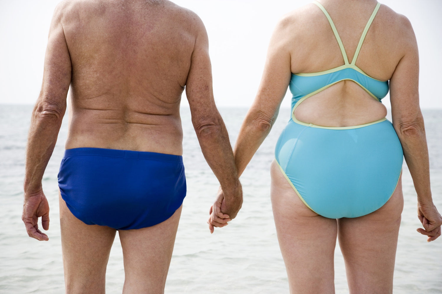 Elderly Couple holding hands on beach