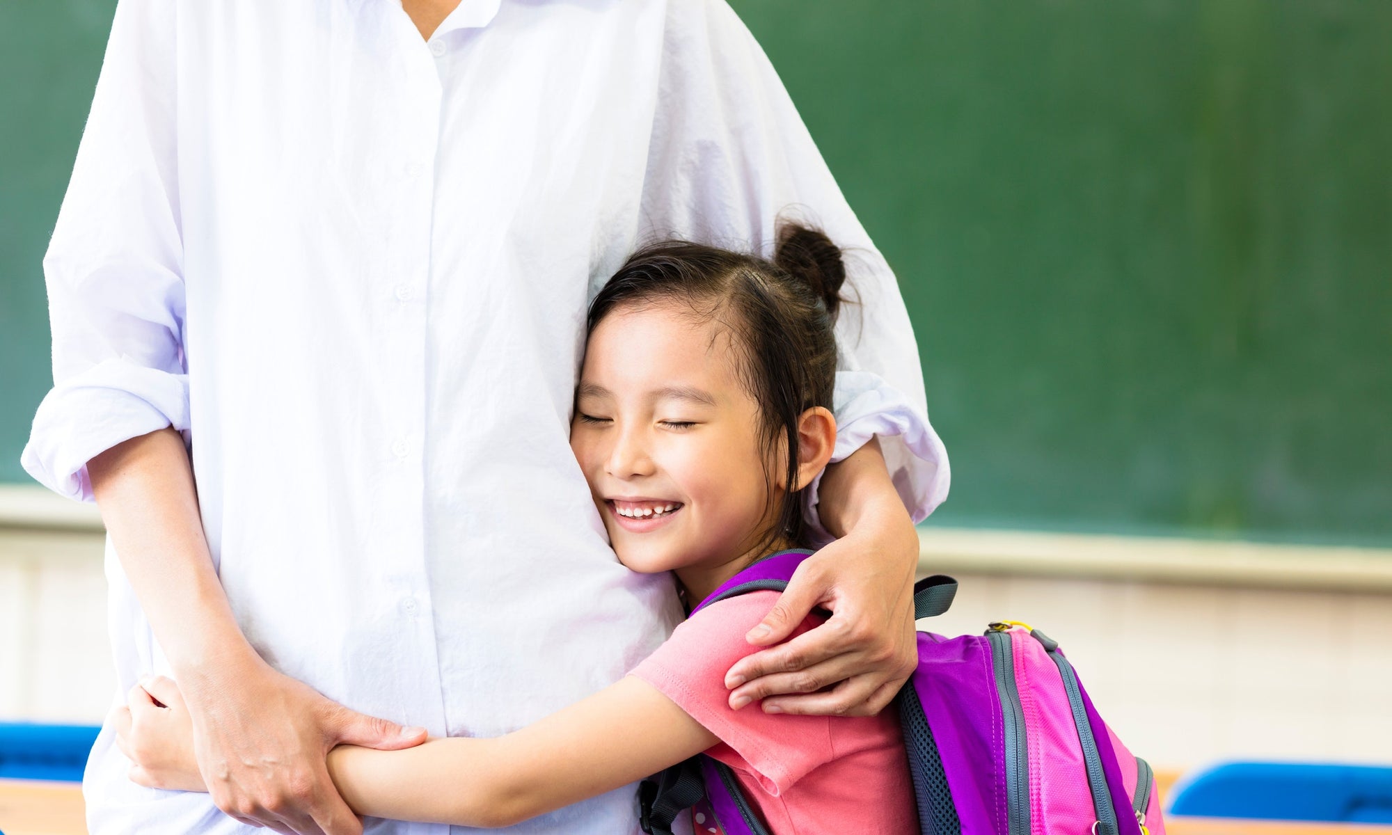 young kid hugging kindergarden teacher