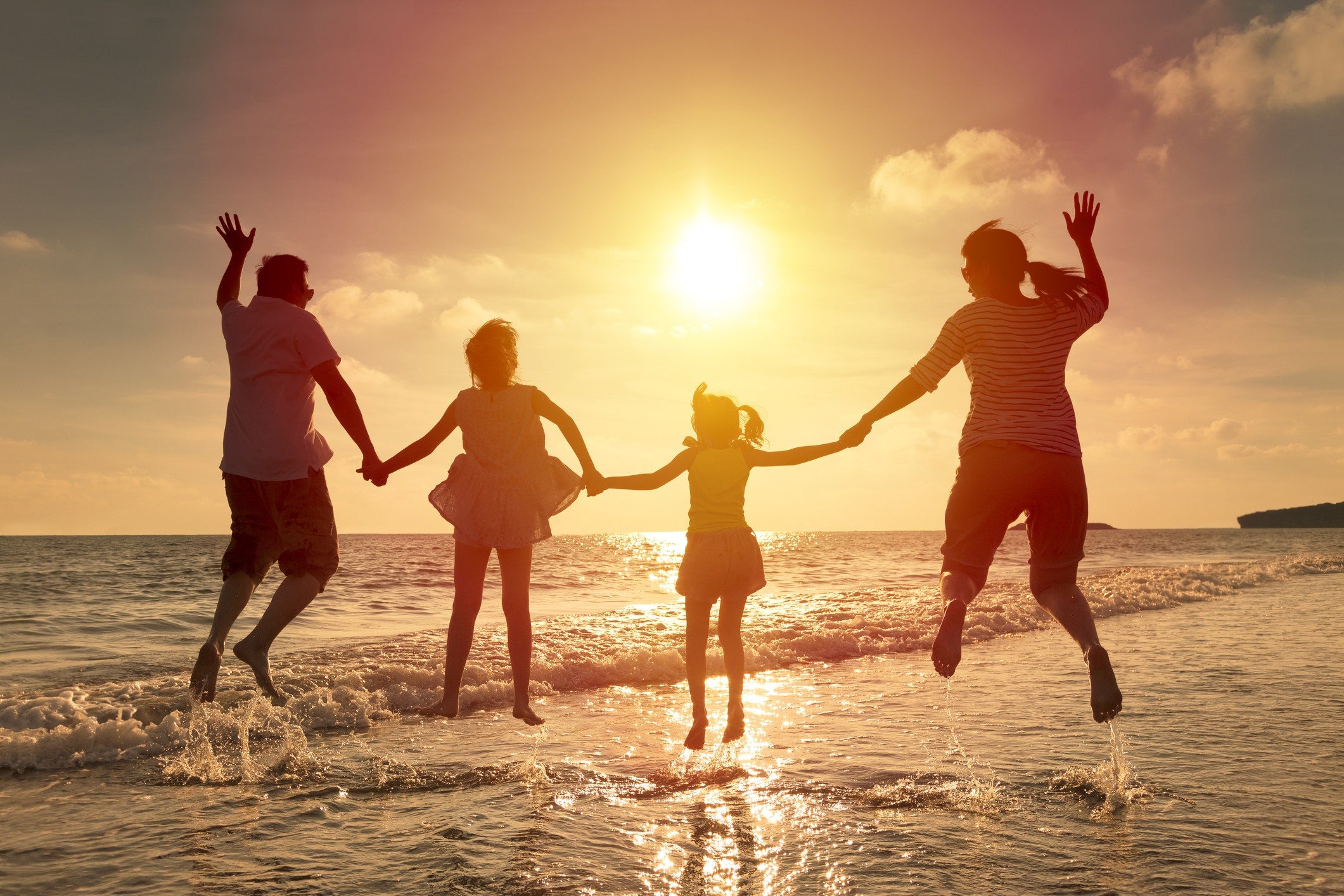 family enjoying and jumping in the air on a beach