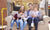 Happy family with kids seated on couch posing for camera