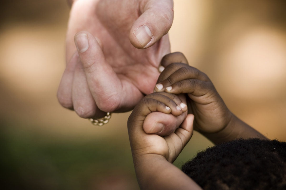 Child holding hand of a woman