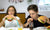 teenage girl and boy  holding big hamburger and drinking coke