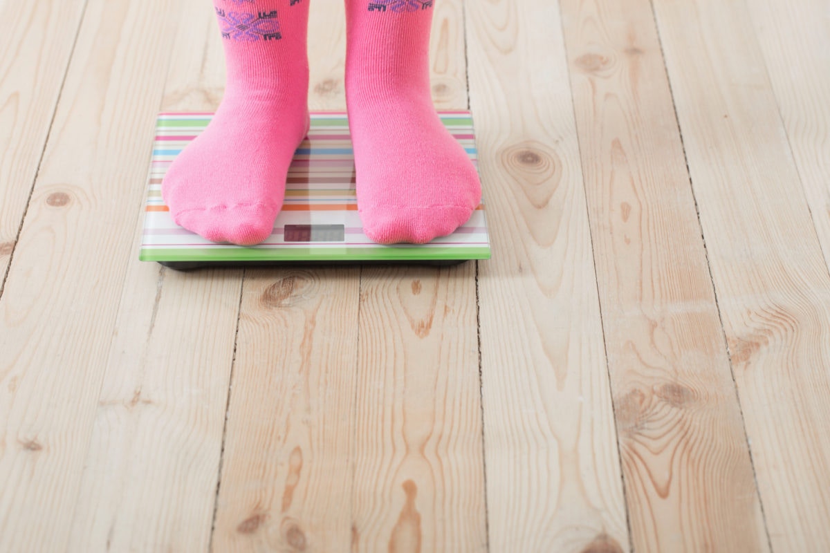 A child is checking weight by wearing socks