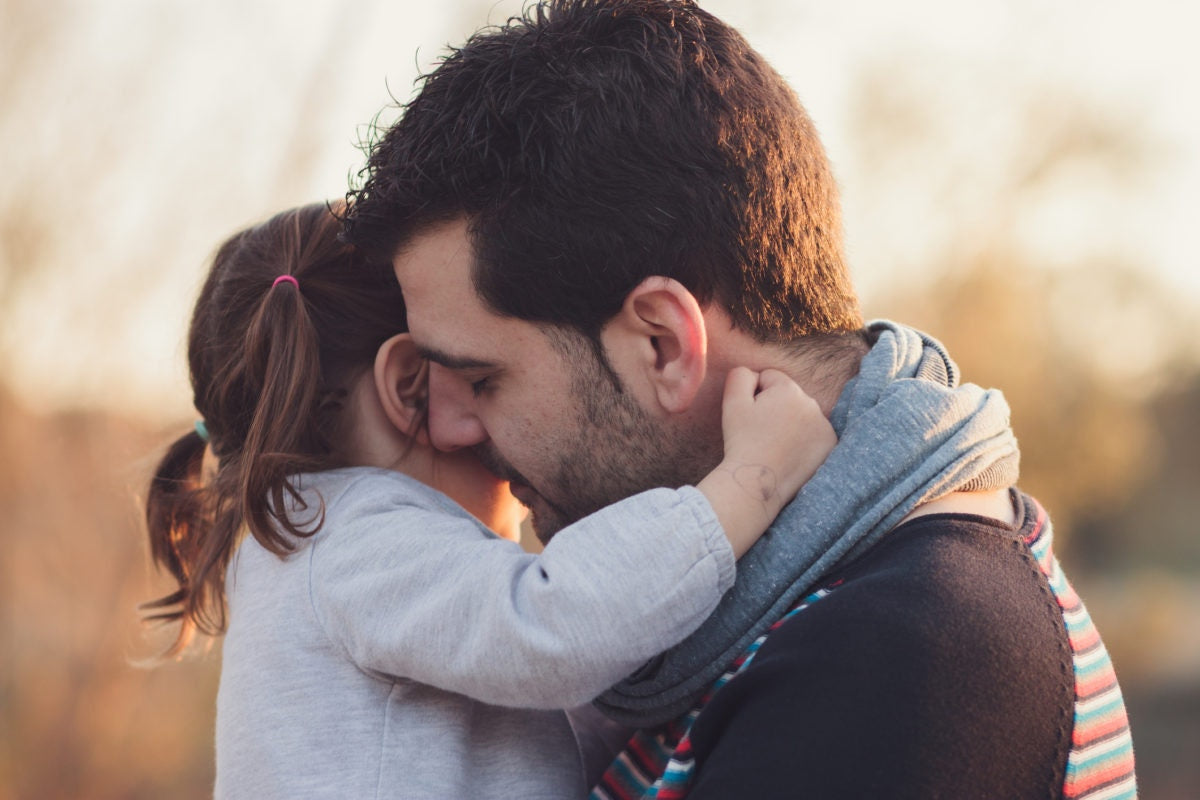 father holding his daughter in his arms