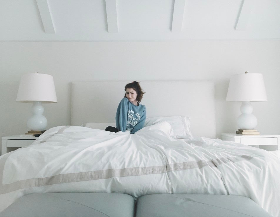 Girl posing while sitting on bed in the morning 