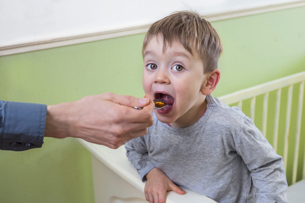 father giving medicine syrup young child boy