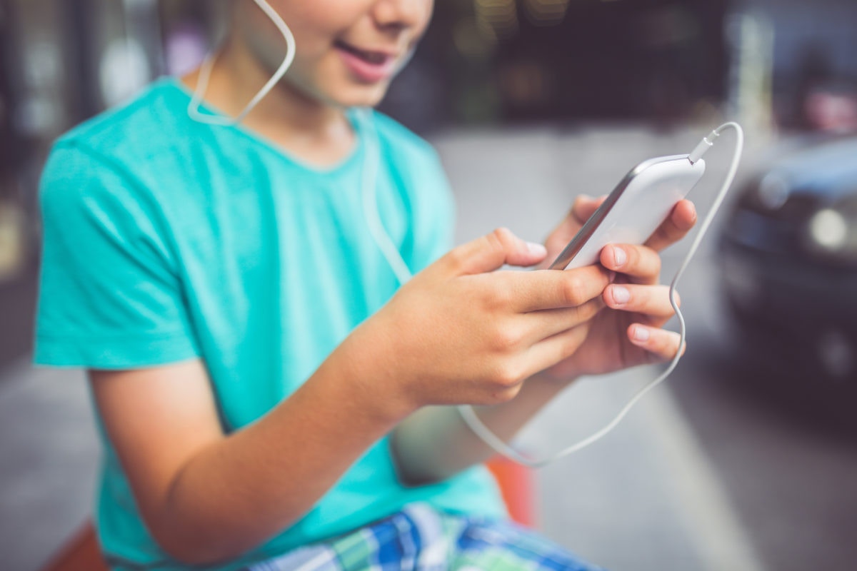 A person listening to music using earphone connected to mobile