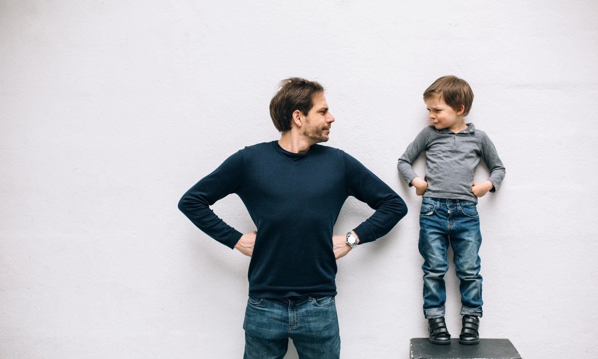 A child standing on a table beside his father