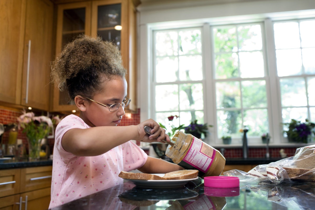 girl making a peanut butter sandwich