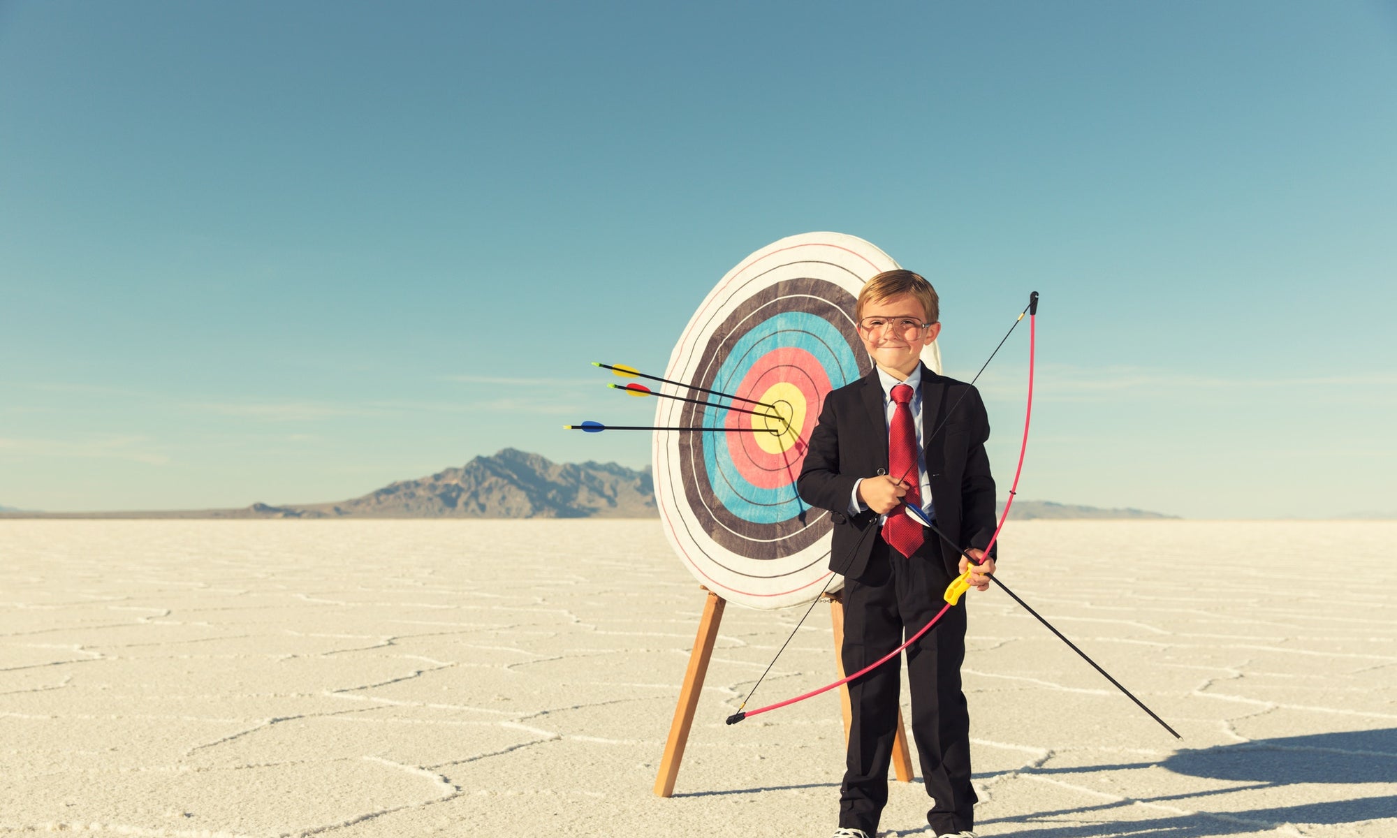 little boy with bow and arrow in snow background