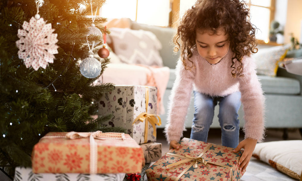 https://www.parent.com/cdn/shop/articles/girl-placing-christmas-presents-under-the-christmas_tree_1600x.jpg?v=1700525011