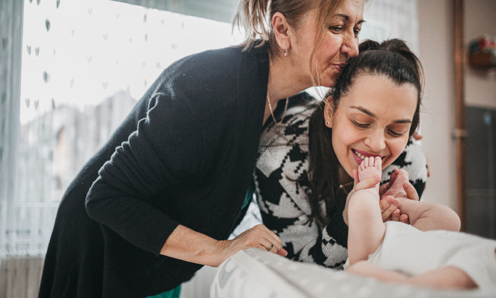 grandmother and daughter looking at a baby