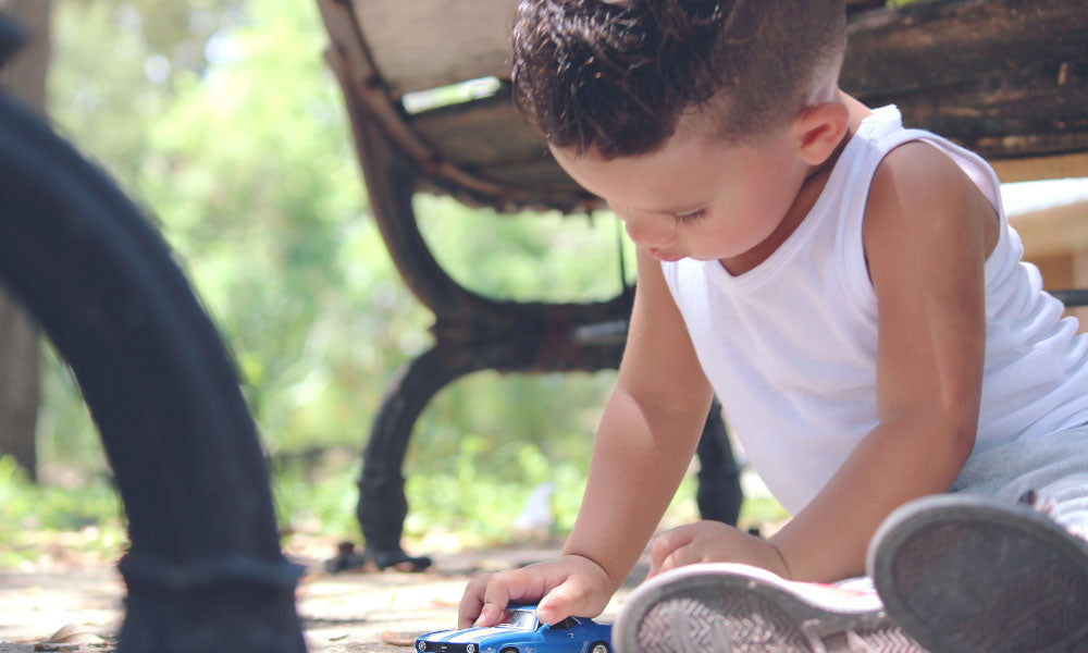 little boy playing with toy car