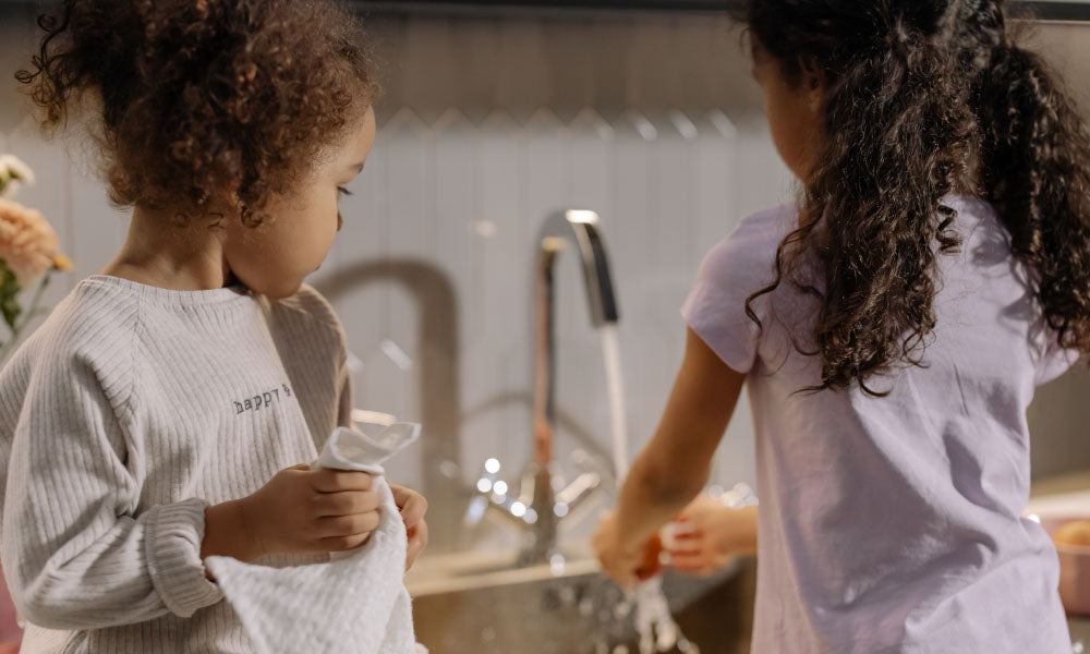 two girls using sink