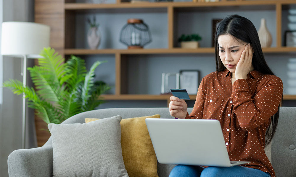 woman looking at computer and phone